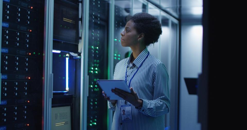 IT engineer standing among server racks in data center room