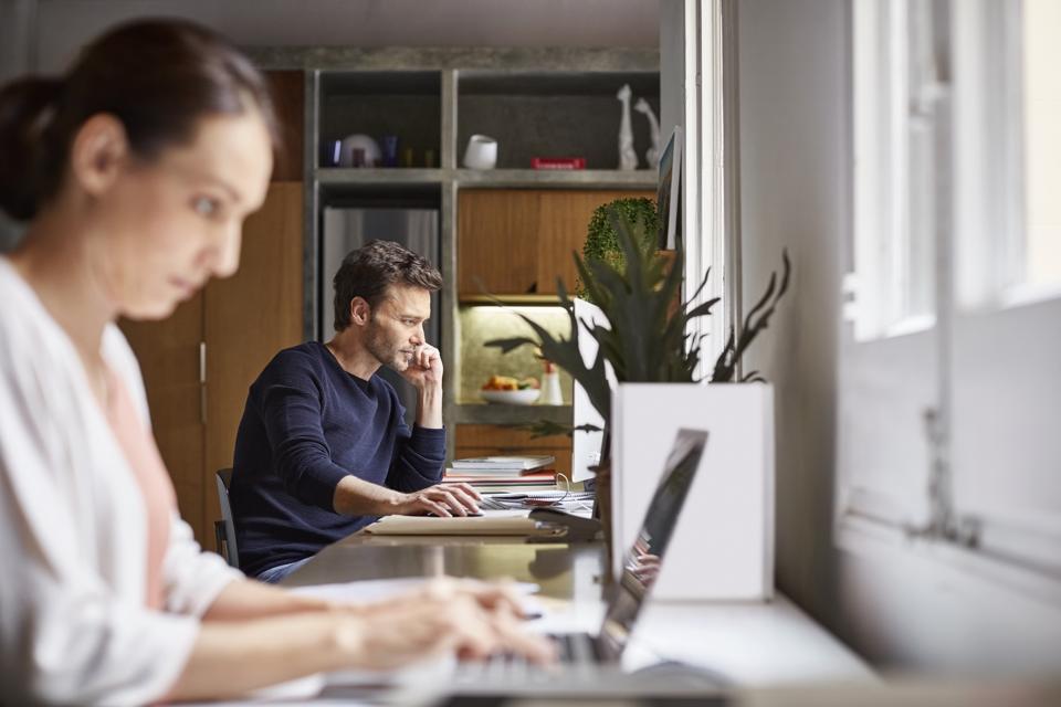 Mid adult business couple working at desk
