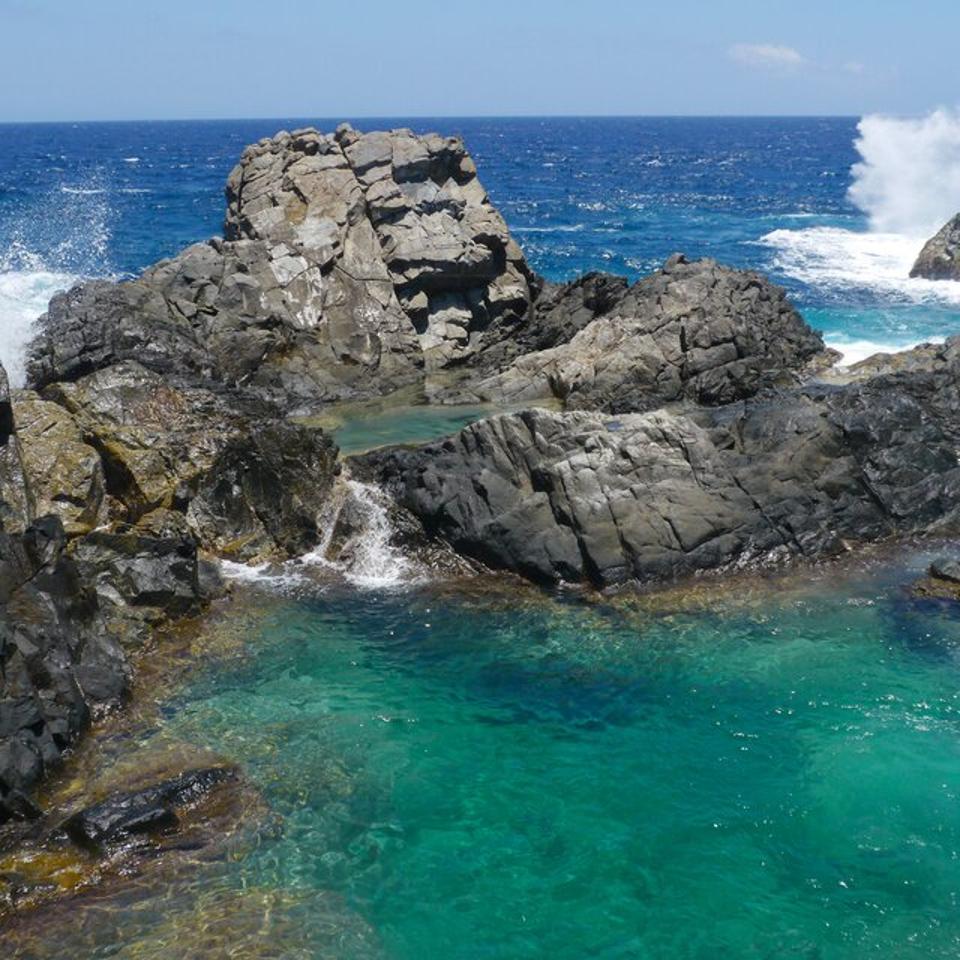 The rocks and ocean form a natural pool in Aruba.