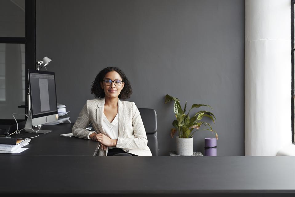 Smiling businesswoman sitting at office desk