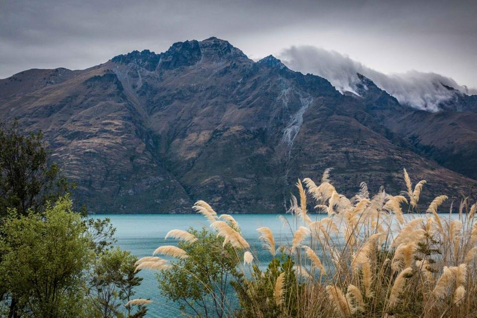 Mountains behind a glacial blue lake.