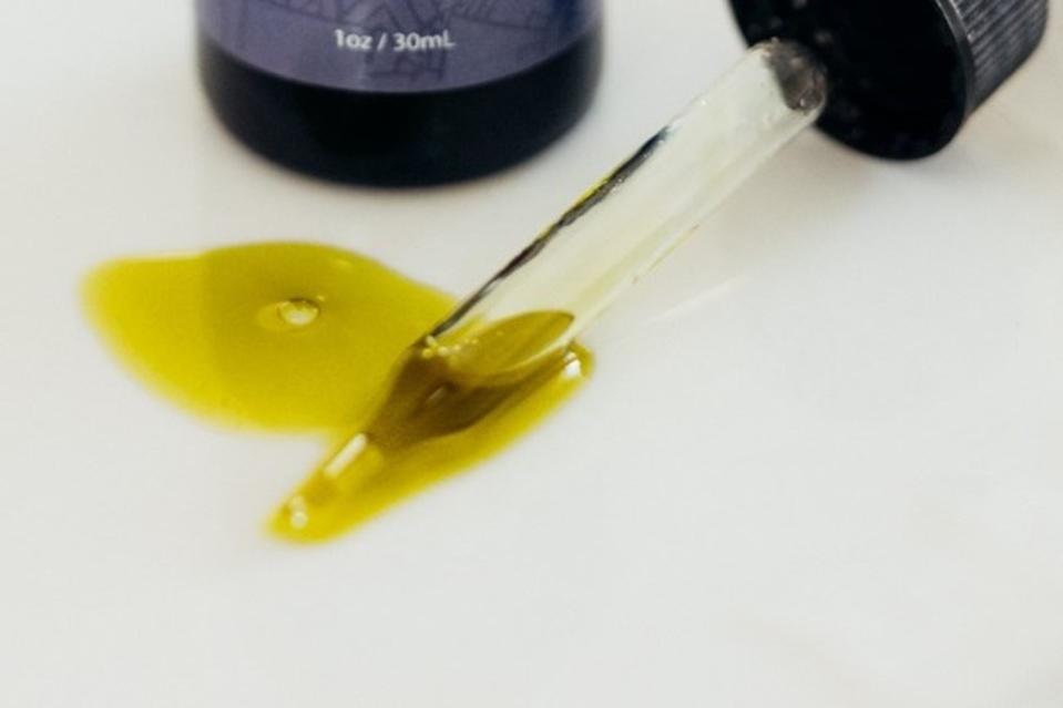 A close-up of an eyedropper with CBD oil.