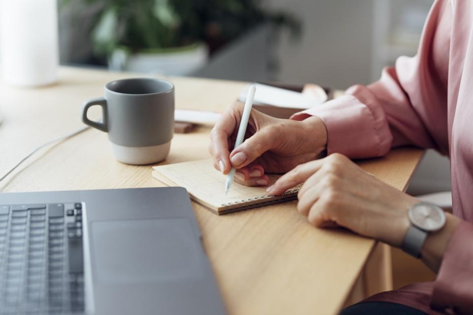 Unrecognizable Mature Businesswoman Working from Home: Writing Notes in her Agenda