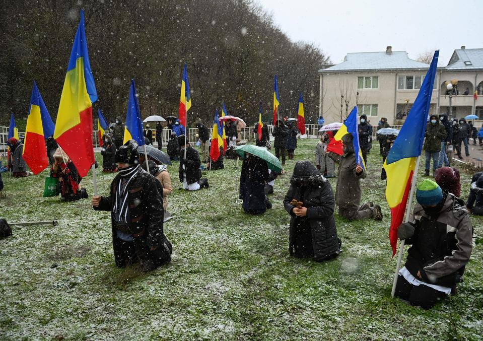 Believers attend a religious service at Saint Andrew's cave in Ion Corvin, southern Romania on November 30, 2020.