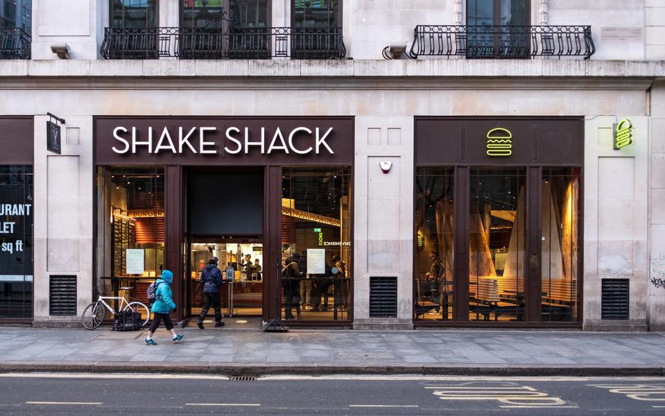 People queuing outside Shake Shack in London. Latest Covid-...