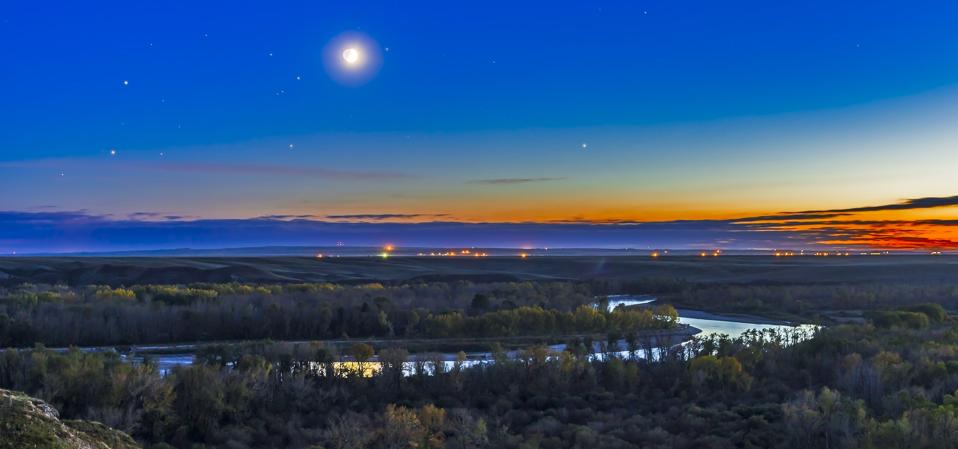 Moon with Antares, Mars and Saturn over Bow River in Alberta, Canada.