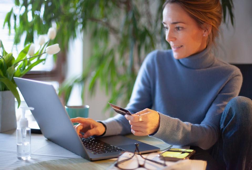 Une femme utilise une carte de crédit dans les achats en ligne