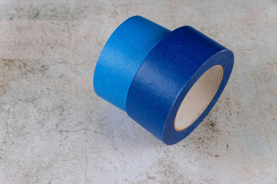 Blue painter tape for multi surfaces on white wall background.