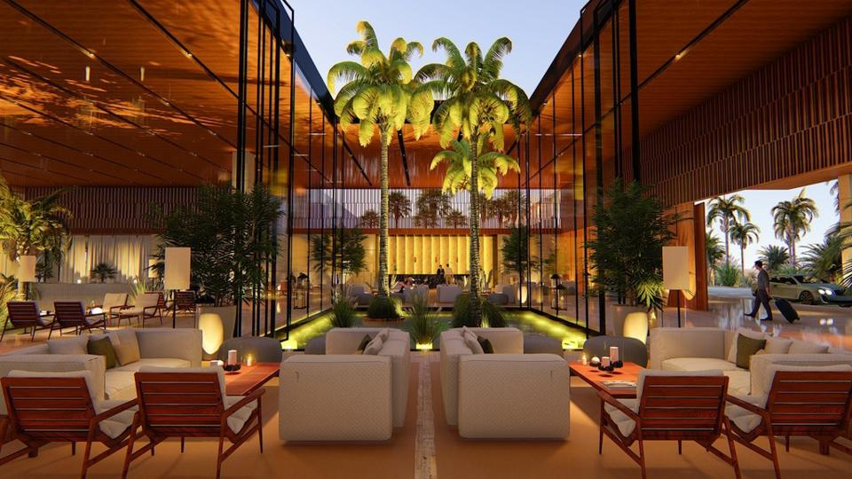 A beautiful, open-air lobby studded with palm trees, a central water feature, and intimate seating areas.