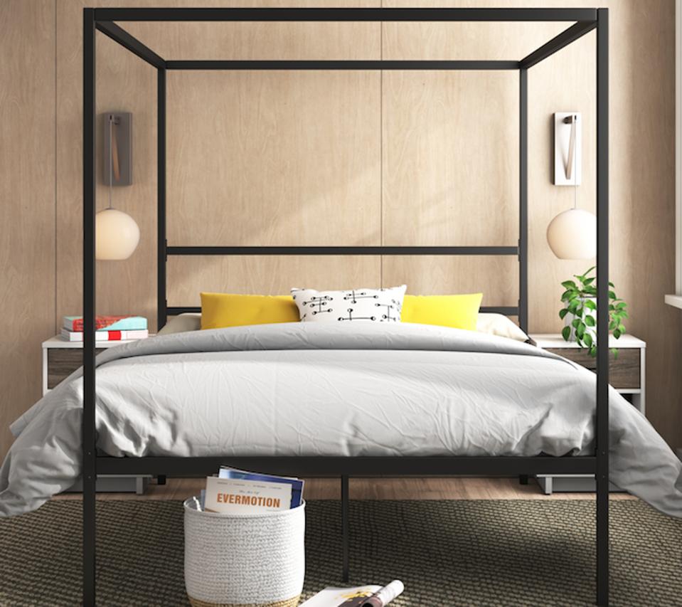 black bed frame in a wood-paneled bedroom