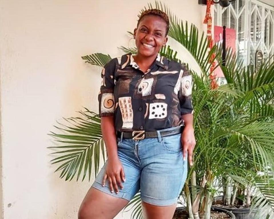 A young Black woman smiling wearing shorts