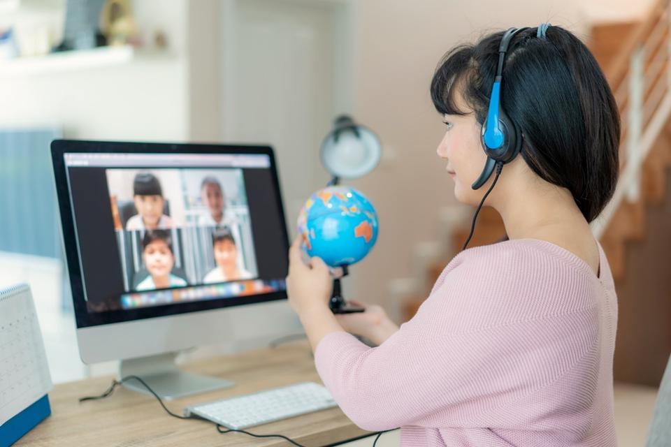 Asian woman teacher teaching geography via video conference e-learning and cheerful elementary school student looking at globe, Homeschooling and distance learning ,online ,education and internet.