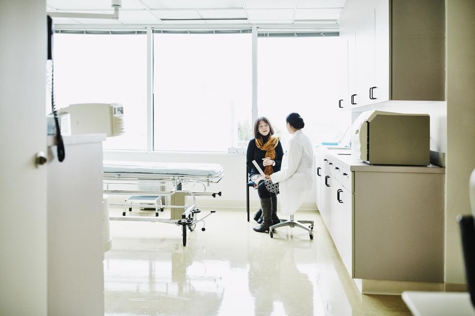 Female doctor in discussion with senior female patient in exam room