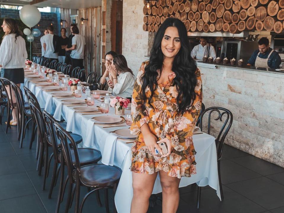 Hili stands in front of a long table set with pink plates and flowers