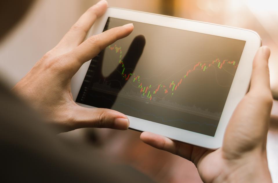 Man checking stock market chart on tablet