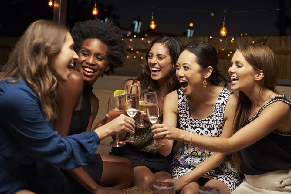Female friends enjoy night out at rooftop bar