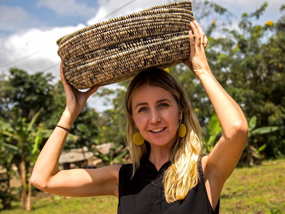 Wallace stands in a field with a woven basket on her head