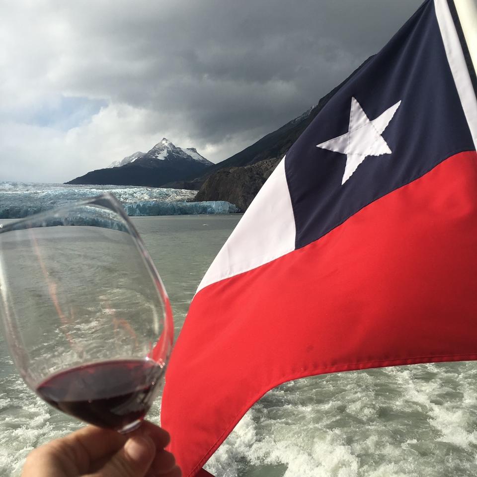 Chilean flag, glacier, mountain peak and glass of red wine