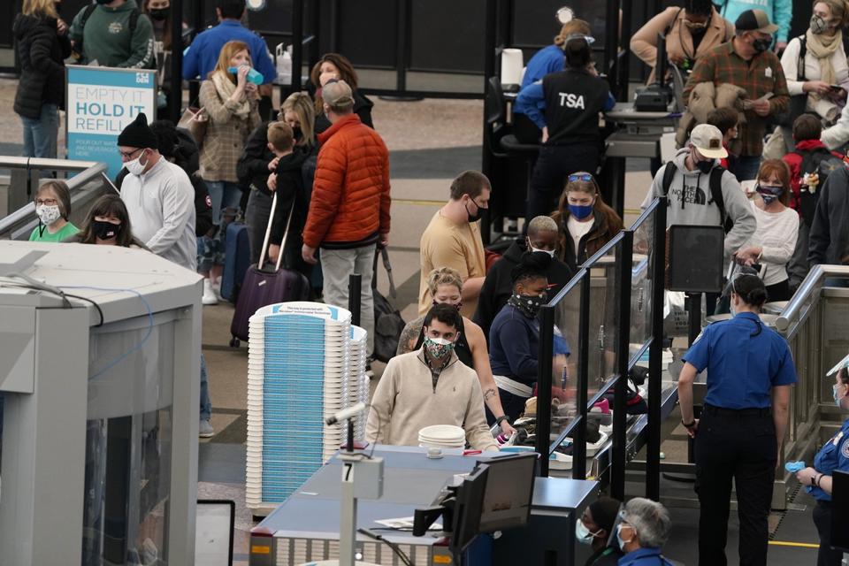 Despite COVID-19, travelers like these at Denver International Airport continue to fly. A new survey finds that many travelers didn't let the pandemic stop them from claiming credit card rewards for free flights and hotel rooms. (AP Photo/David Zalubowski)