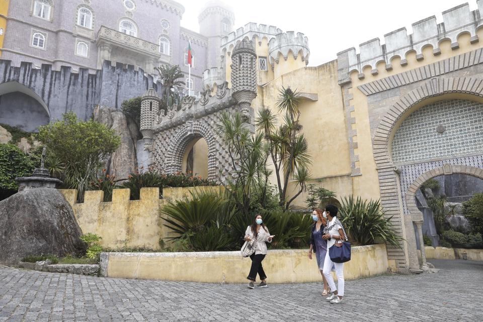 A guide leads two visitors around Pena Palace in Sintra, Portugal