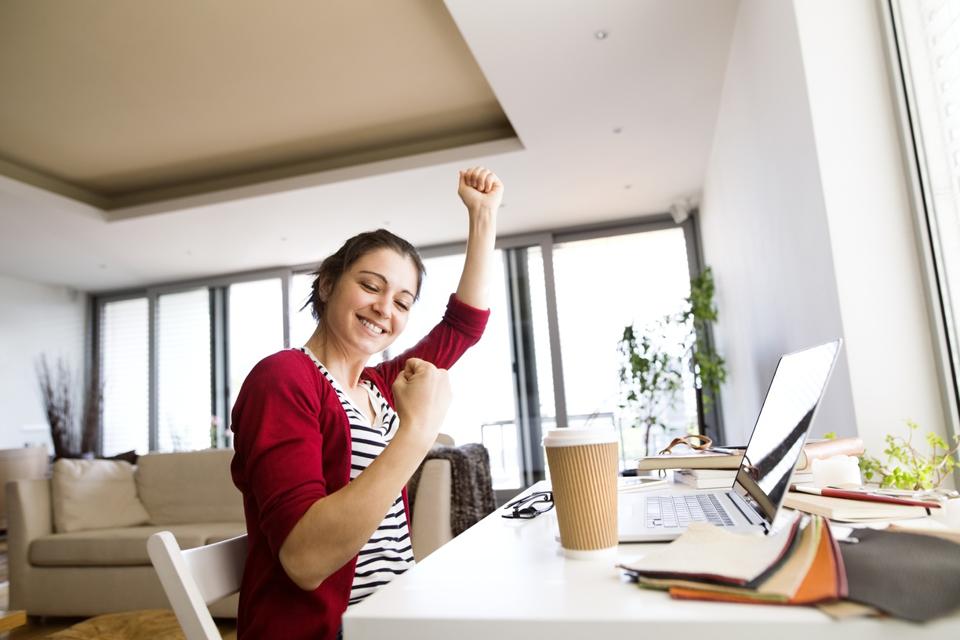 Happy woman at home receiving the good news of a job offer