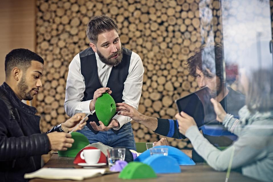 Creative business people inspecting prototype