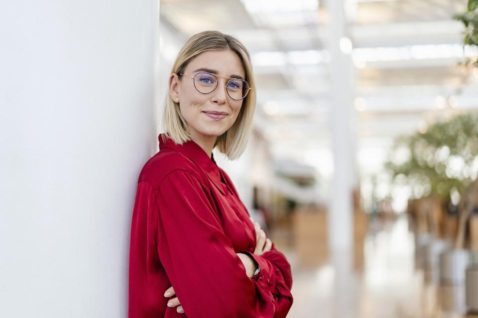 Portrait of a confident young businesswoman leaning against a column