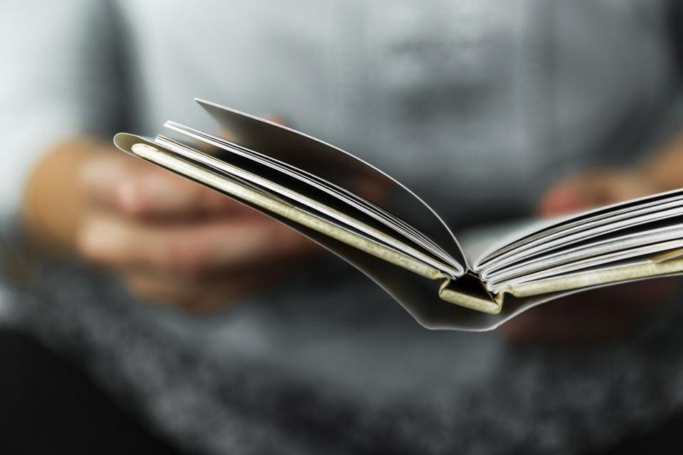 Young Women Reading A Small Book