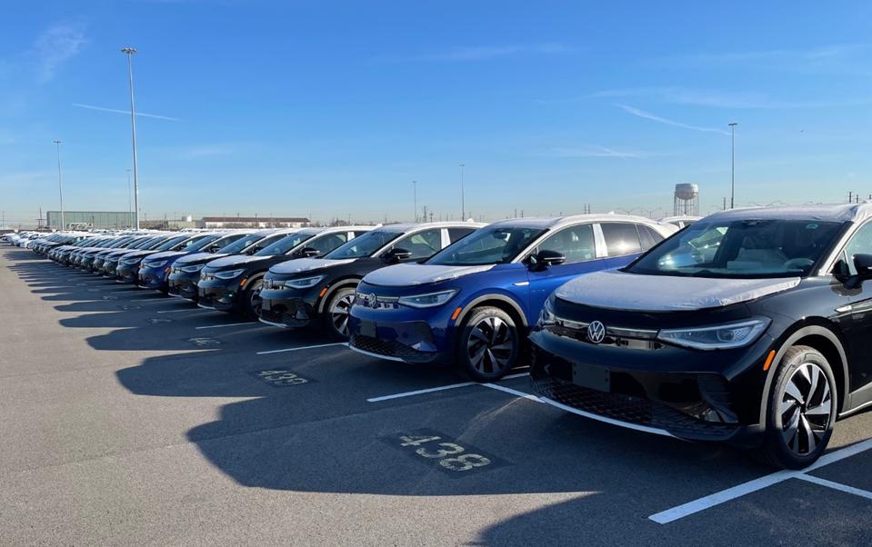 Dozens of VW ID.4 EVs lined up in parking lot.