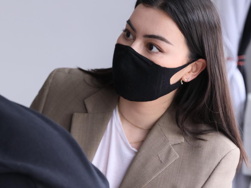 Woman wearing face mask measuring someone for photo shoot