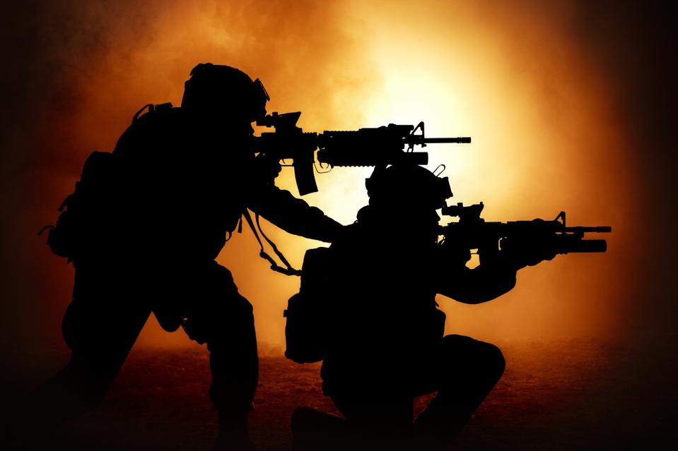 Two soldiers surrounded by flame and smoke