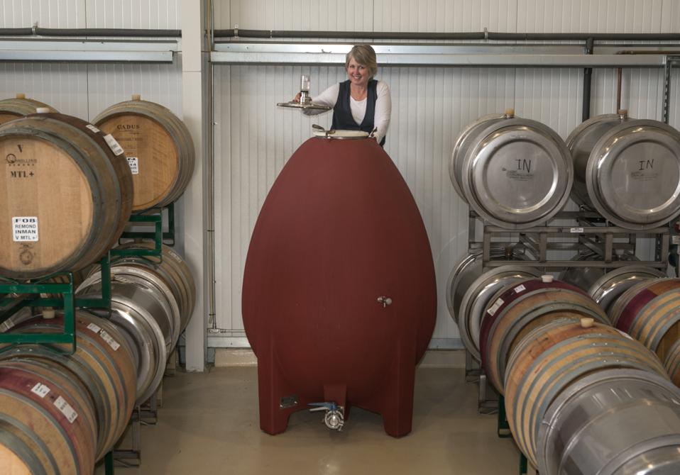 Winemaker Kathleen Inman checks fermentation progress in an egg-shaped tank.