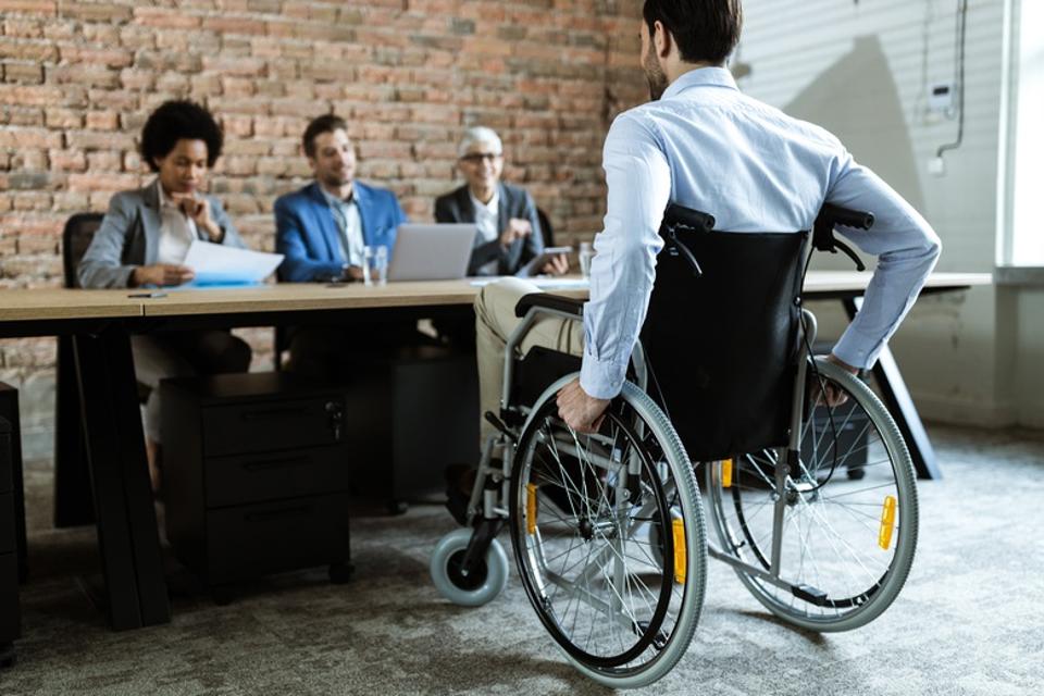 Back view of a businessman in a wheelchair on a job interview.