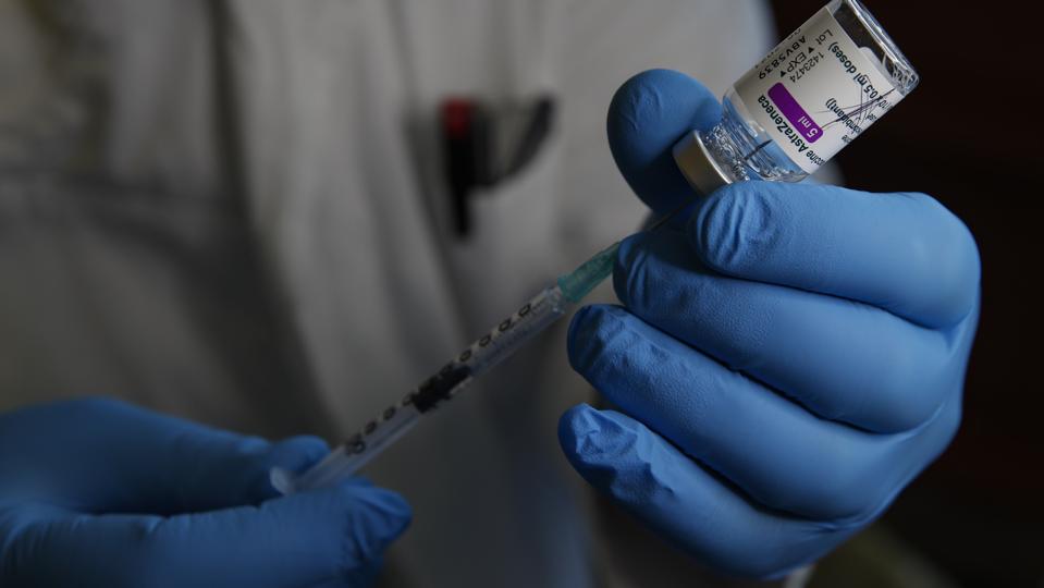 A health worker prepares a dose of the AstraZeneca COVID-19...