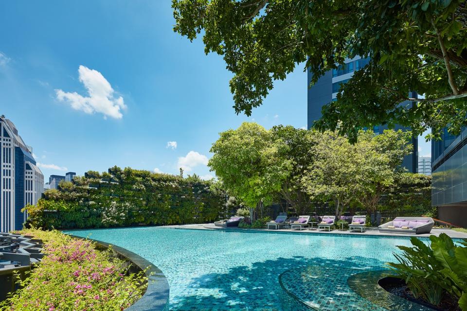 The pool at the Hyatt Regency Bangkok Sukhumvit hotel in Thailand is shaded by trees