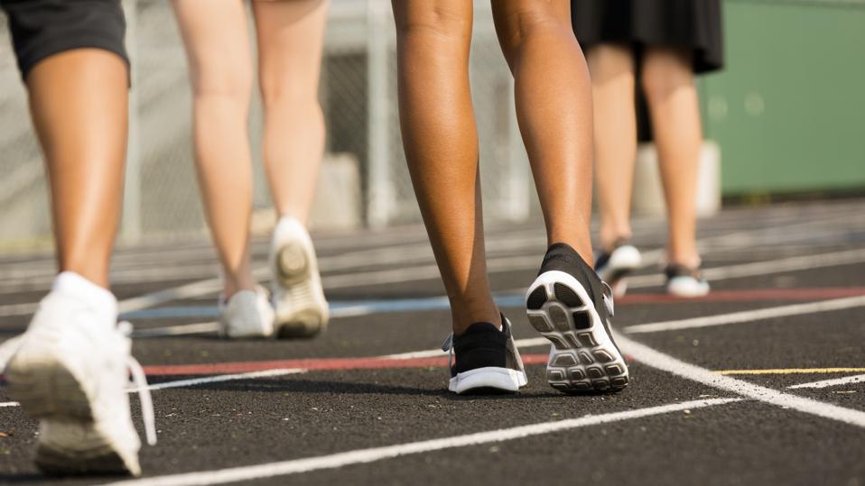 Sports:  Women exercise by walking around a track.