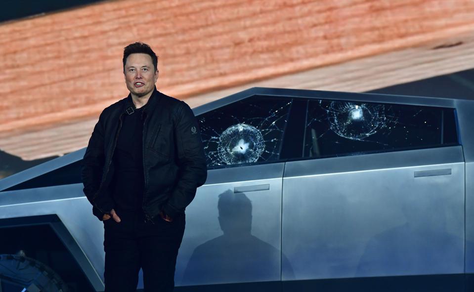 Elon Musk stands in front of the shattered windows of the newly unveiled all-electric battery-powered Tesla's Cybertruck