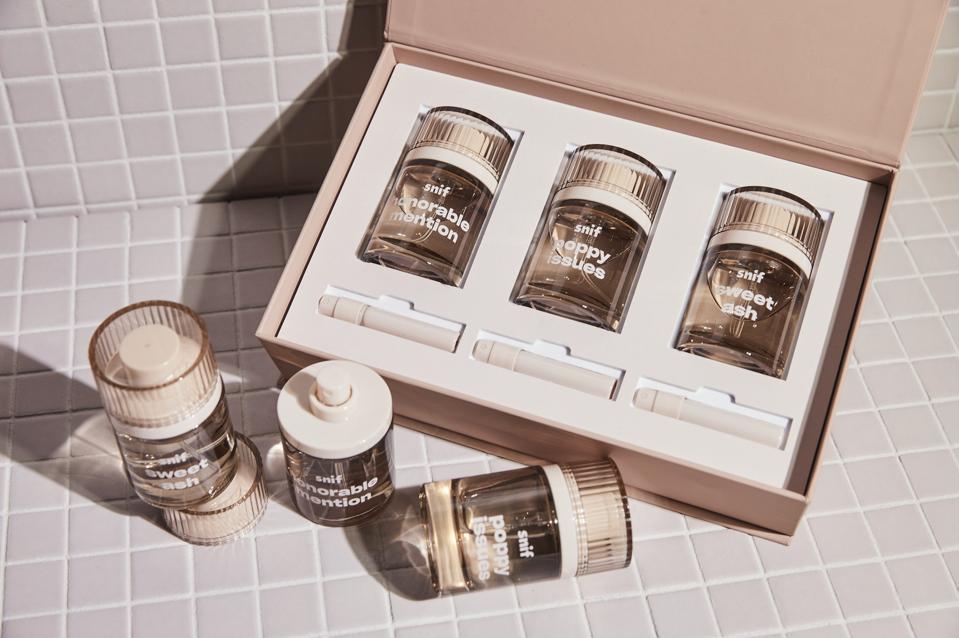 a box of three amber colour transparent bottles of perfume