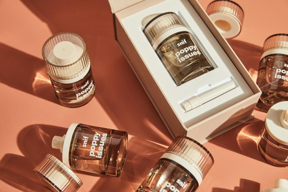 three amber colour transparent bottles of perfume