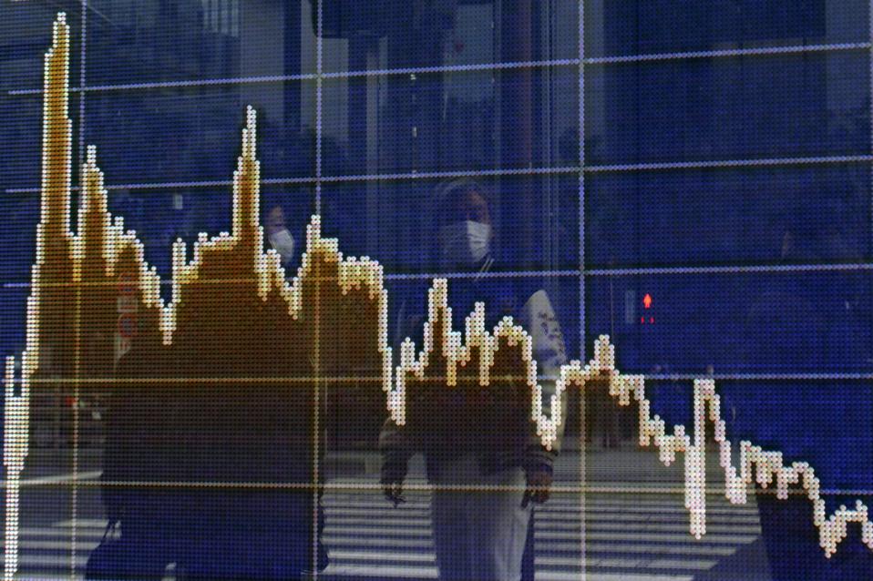 People seen reflected on an electronic board showing Nikkei...