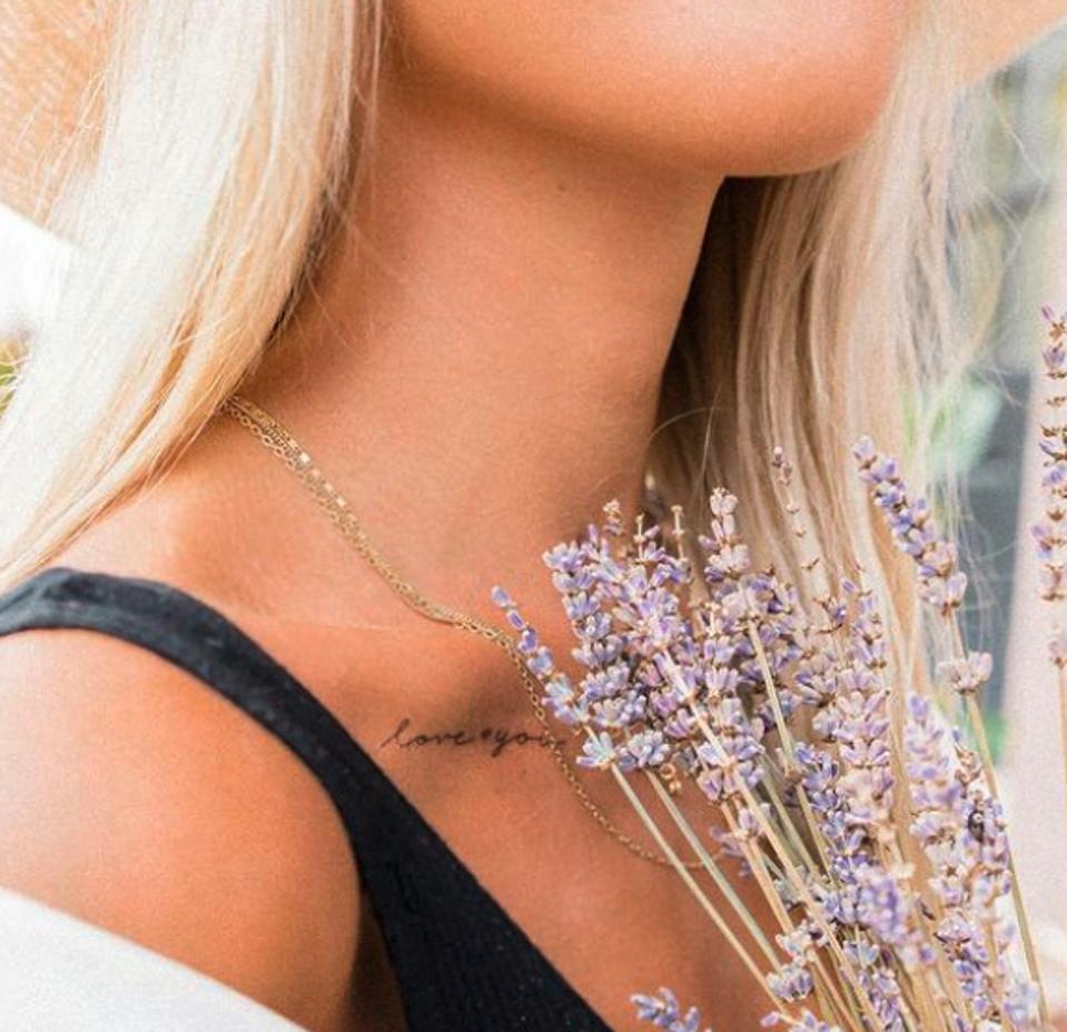 a blonde woman with small tattoo to the collar bone