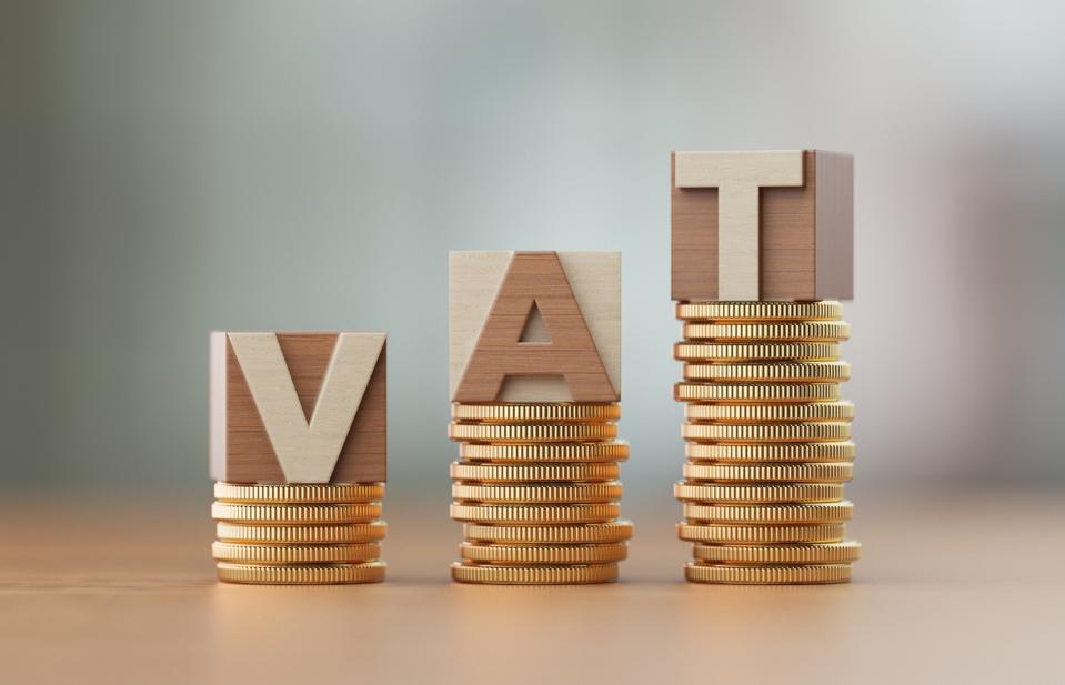 Cube Blocks And Coins Forming VAT Text Over Defocused Background