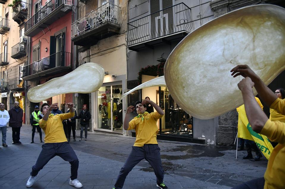 Pizzaioli group in Naples perform ″twirling″ pizza.