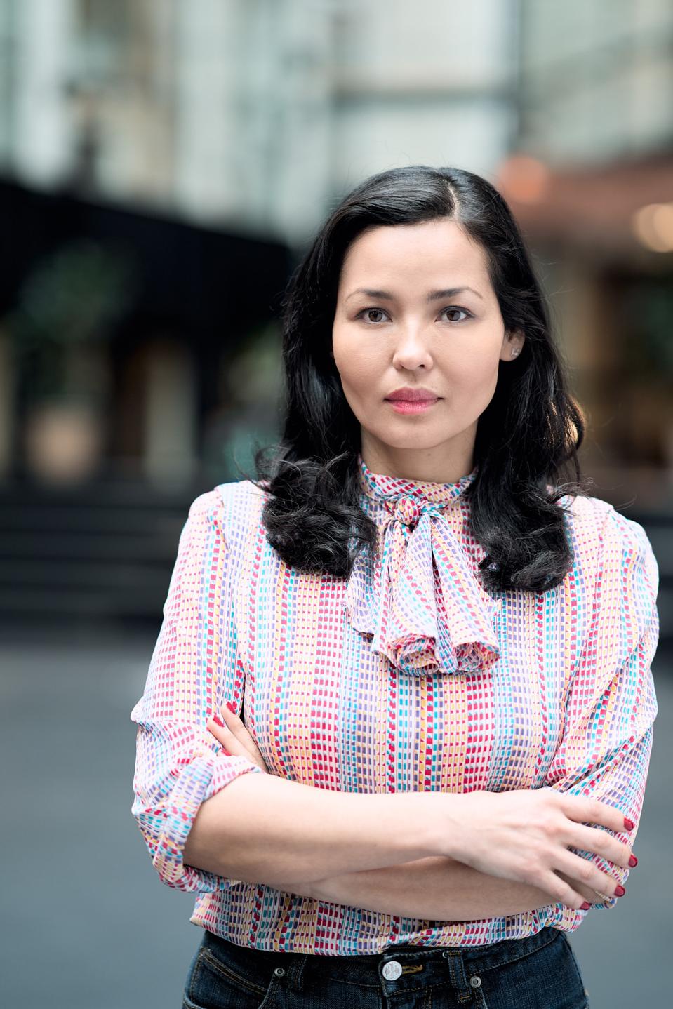 Picture of Gina Pari, women in colour with a blurred picture of an office building.