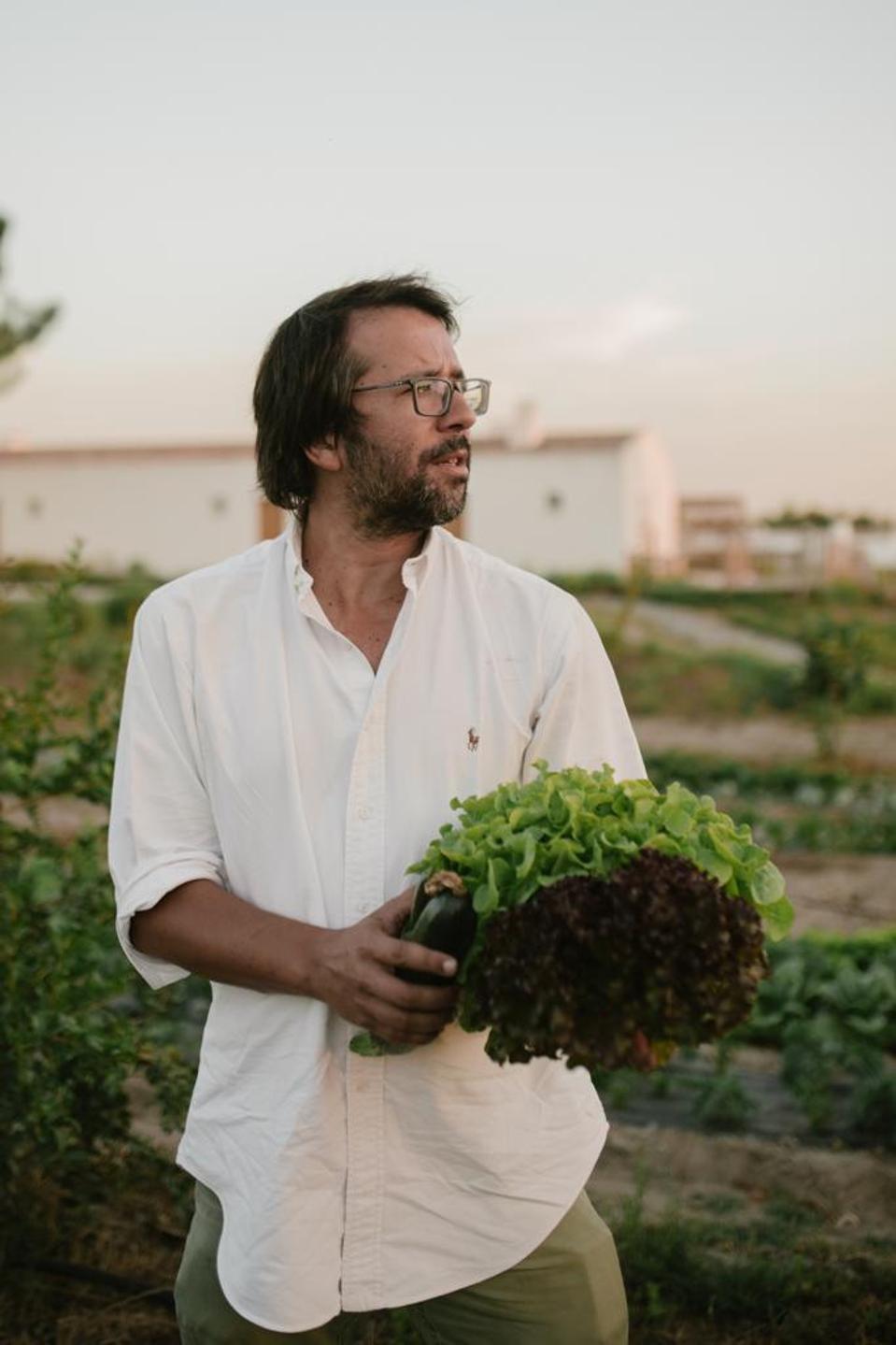 The owner of the Craveiral hotel in the Alentejo, Portugal, holds a basket of leaves