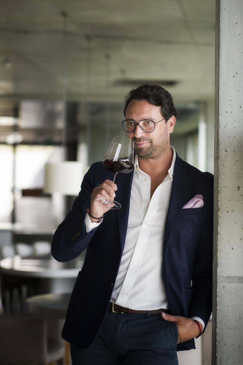 Portuguese wine entrepreneur Claudio Martins savors a glass of red wine