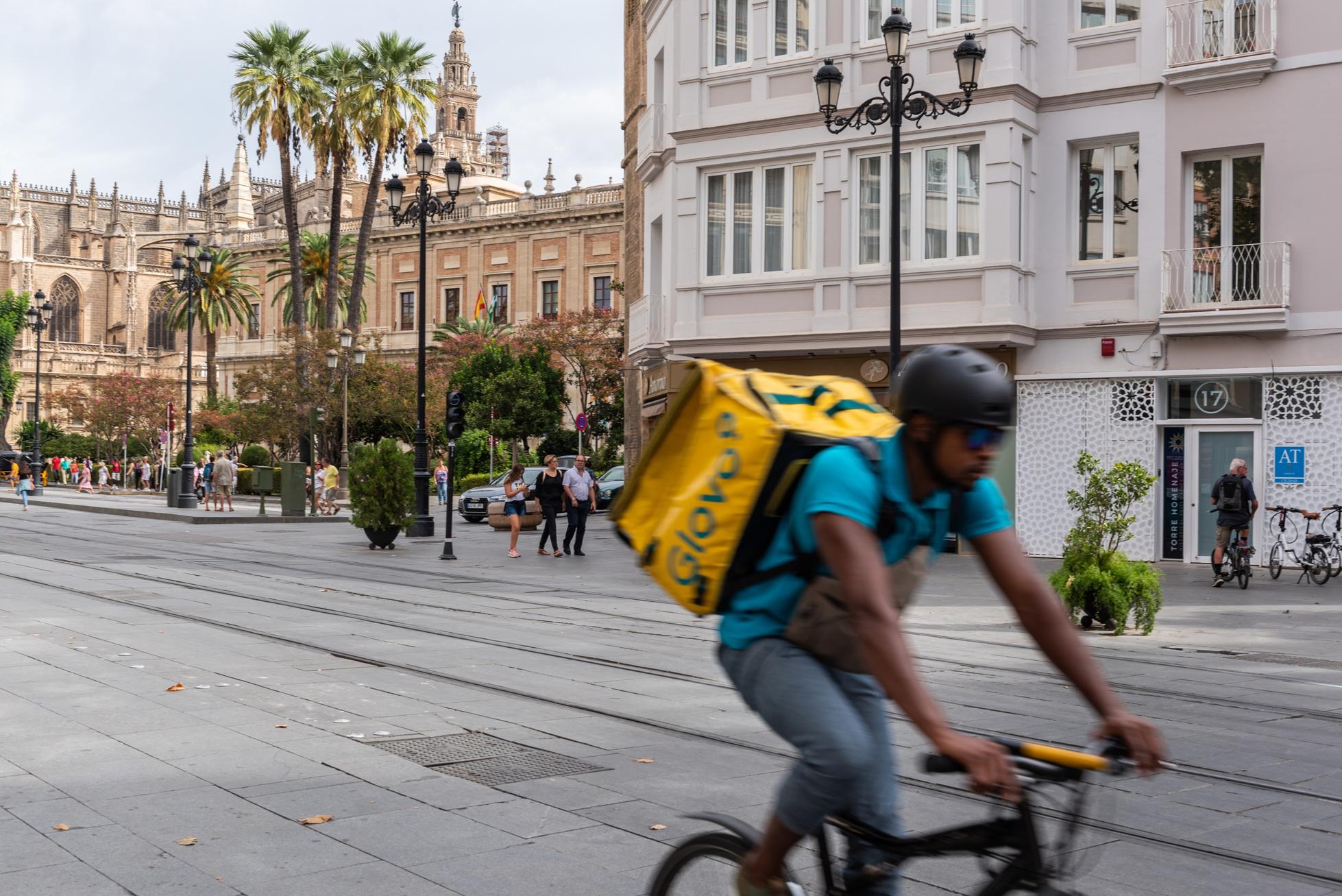 Glovo delivery man riding bicycle on the street...