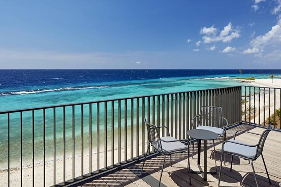 A deck with chairs near the ocean.