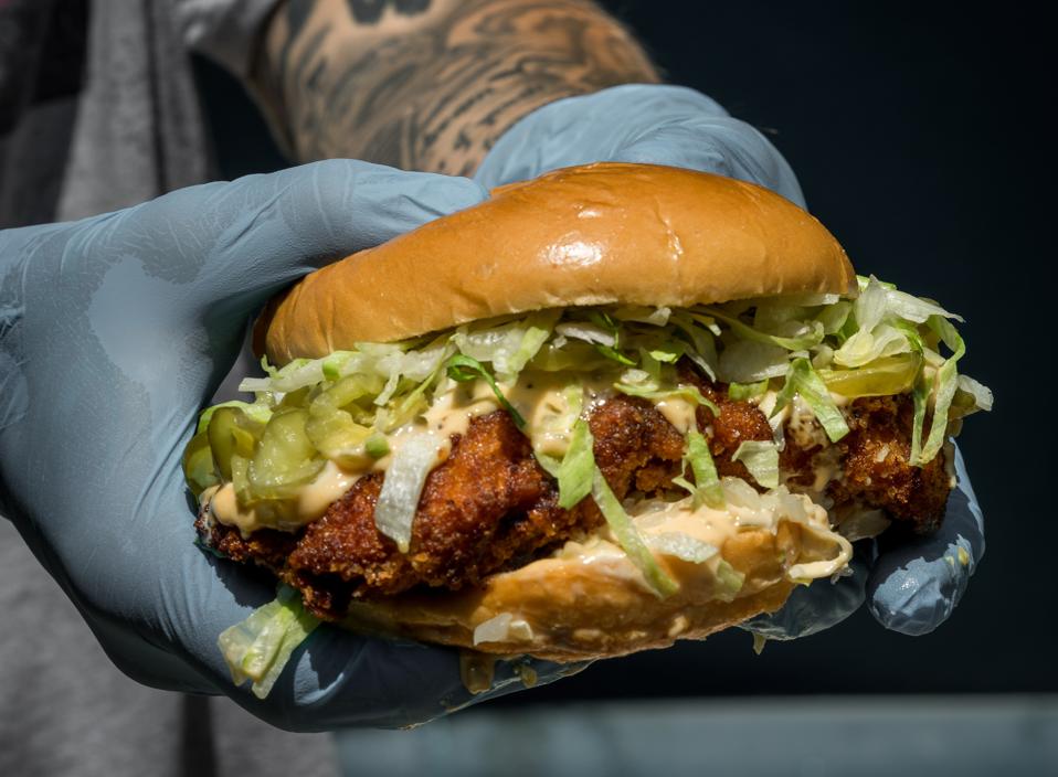 Man holding a big chicken sandwich