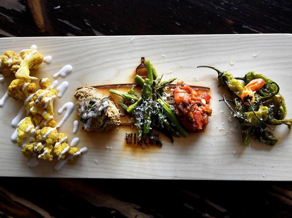 A vegan charcuterie board with cauliflower, eggplant and peppers